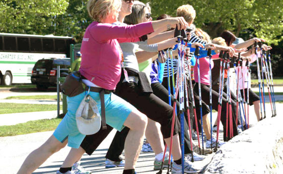 A group of people lunging in an outdoor exercise class