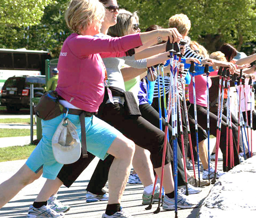 A group of people lunging in an outdoor exercise class