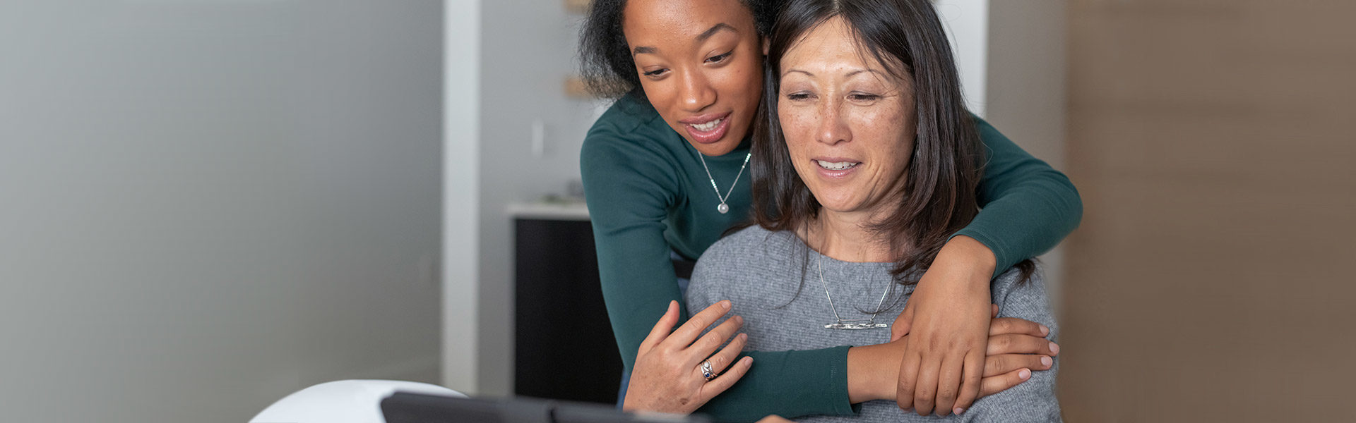 A woman and her mother looking at a computer screen.