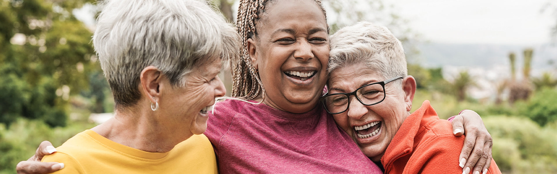 Stroke survivor being embraced by two friends laughing