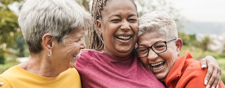 Stroke survivor being embraced by two friends laughing