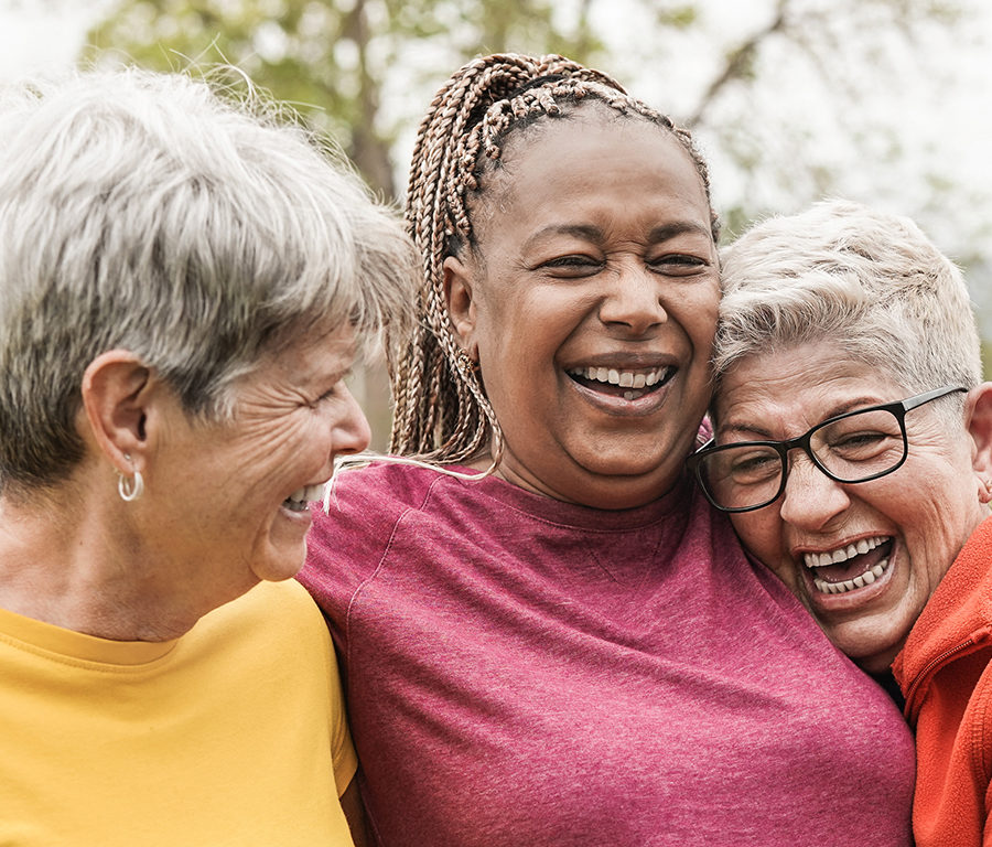 Stroke survivor being embraced by two friends laughing