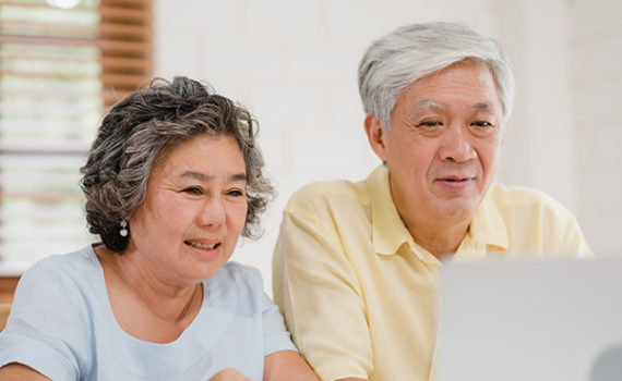 Two older people looking at a computer