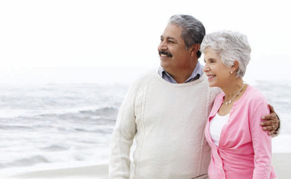 Older couple on beach arms around each other