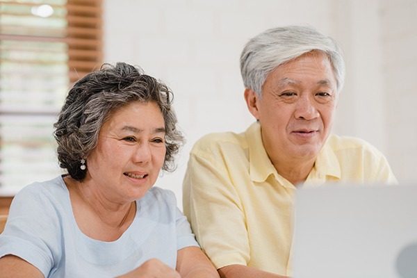 Elderly couple looking at stroke recovery resources on a laptop