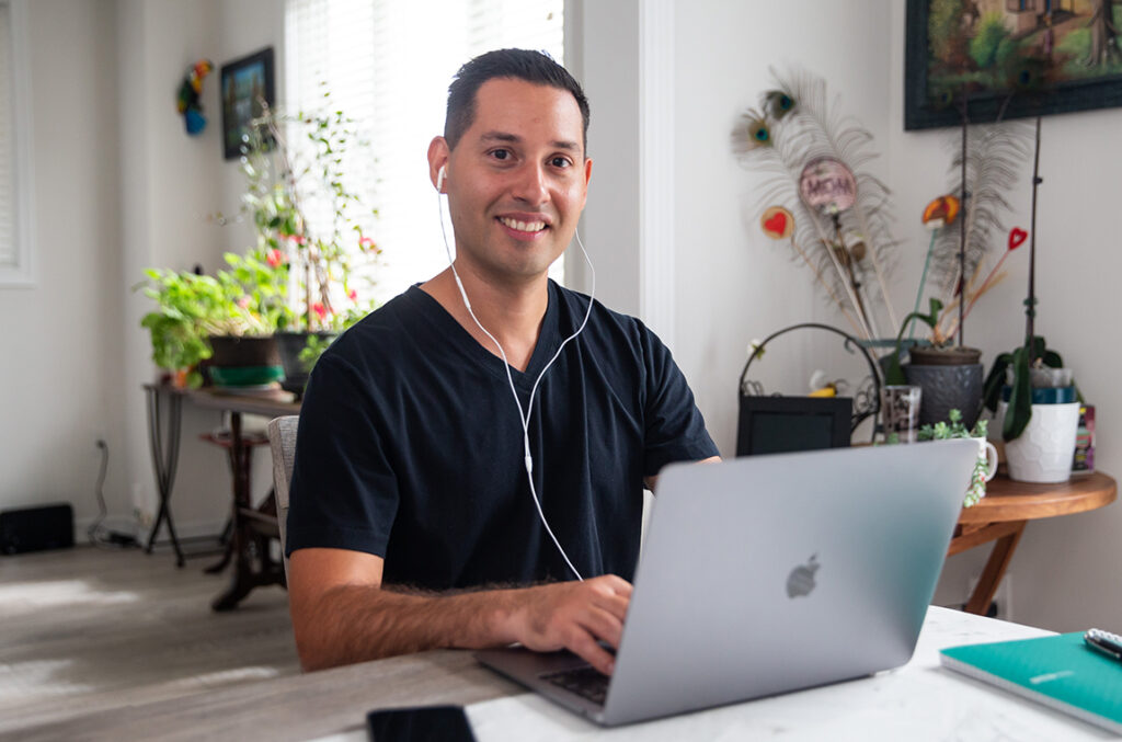 Smiling stroke survivor Jonathan typing on laptop