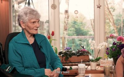Senior woman in a wheelchair talking to an expert about spasticity