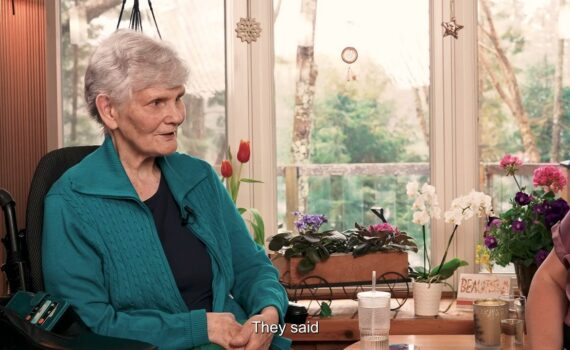 Senior woman in a wheelchair talking to an expert about spasticity